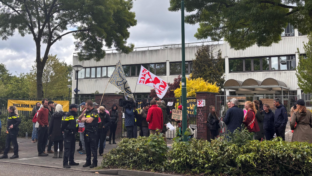 De groep demonstranten met vlaggen met de tekst 'Peace Now'