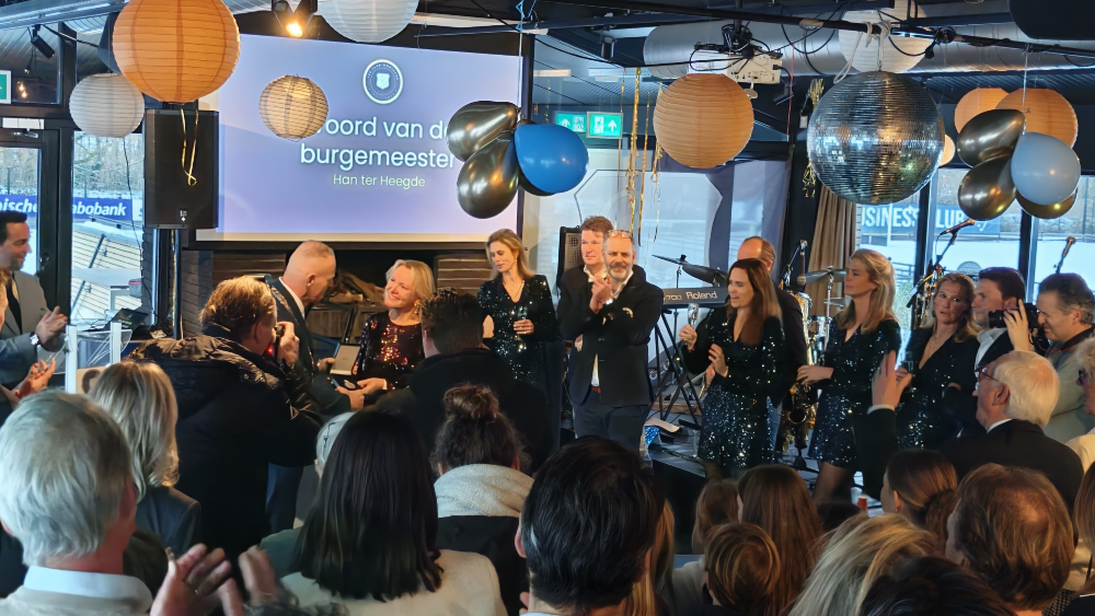 Overhandiging erepenning in een overvol clubhuis